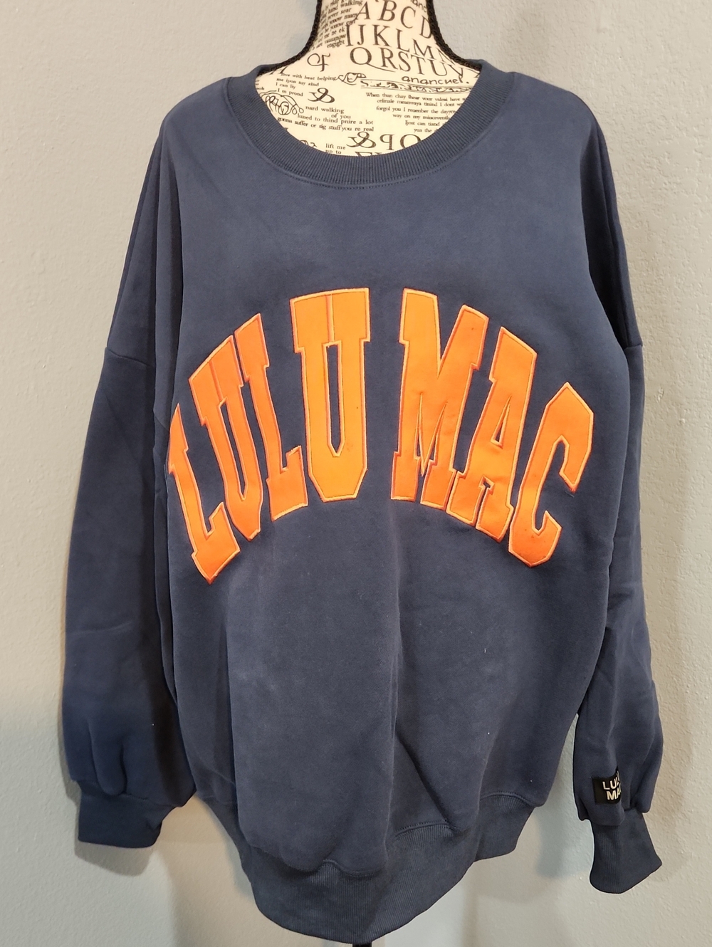 Lulu Mac Navy Sweatshirt with Orange Lettering.